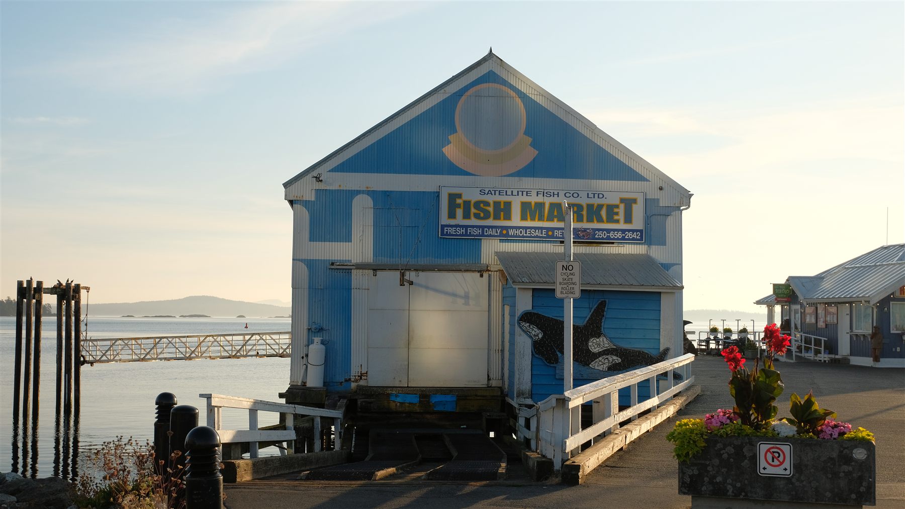 A blue fish market building on a dock