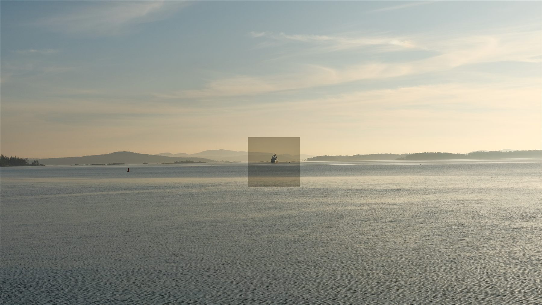 A boat crossing calm water at dusk