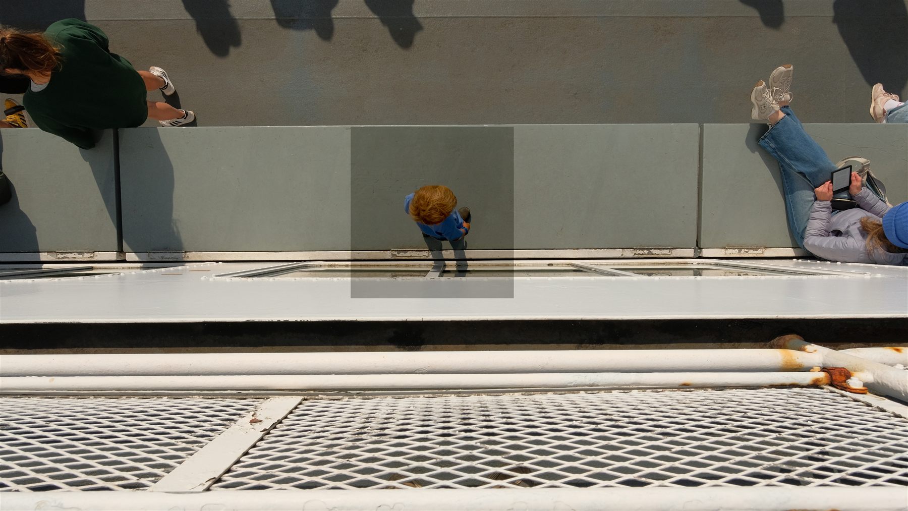 A boy looking out over the railing on the ferry to the island