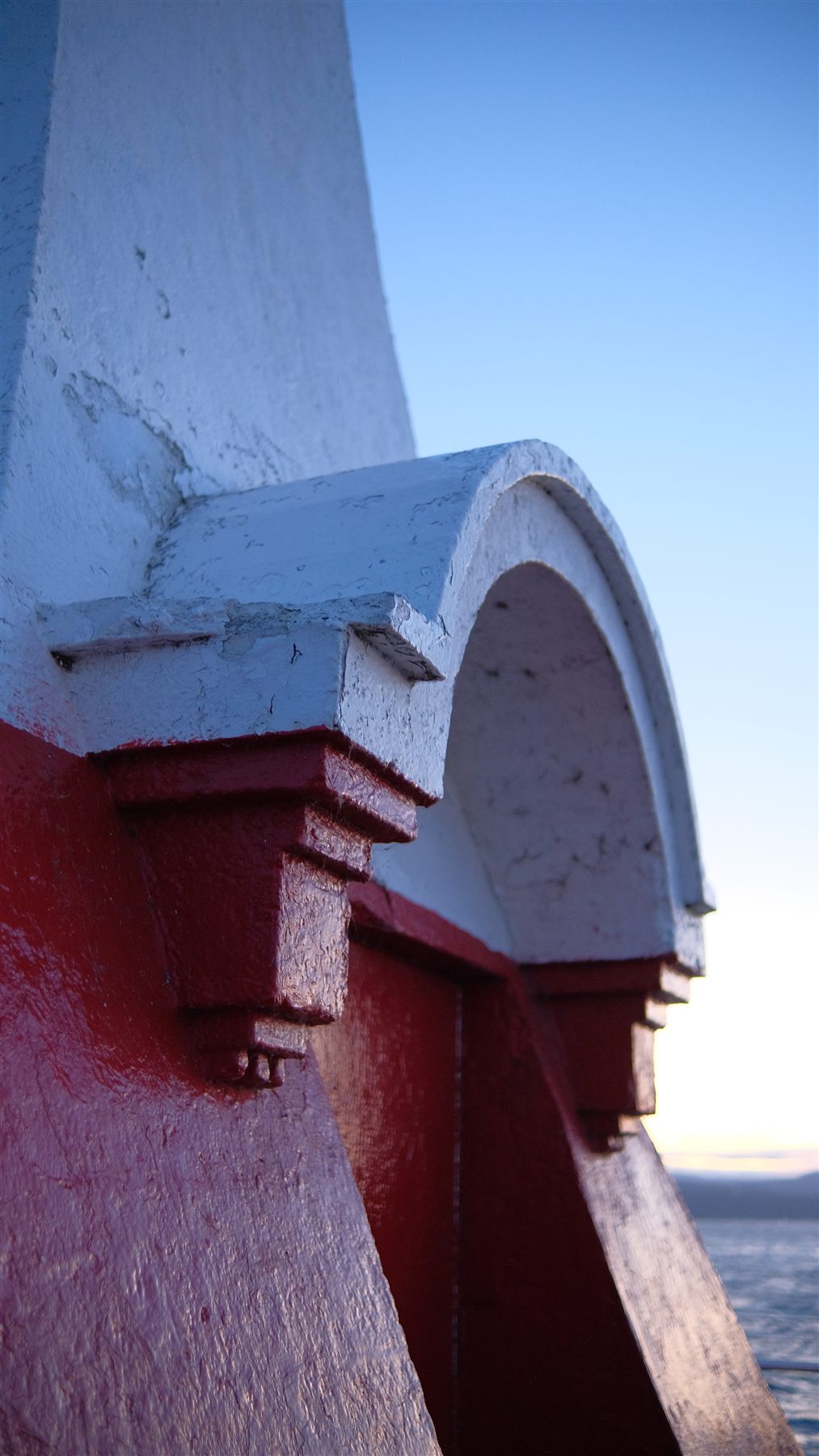 Red and white painted post against a blue sky in Victoria