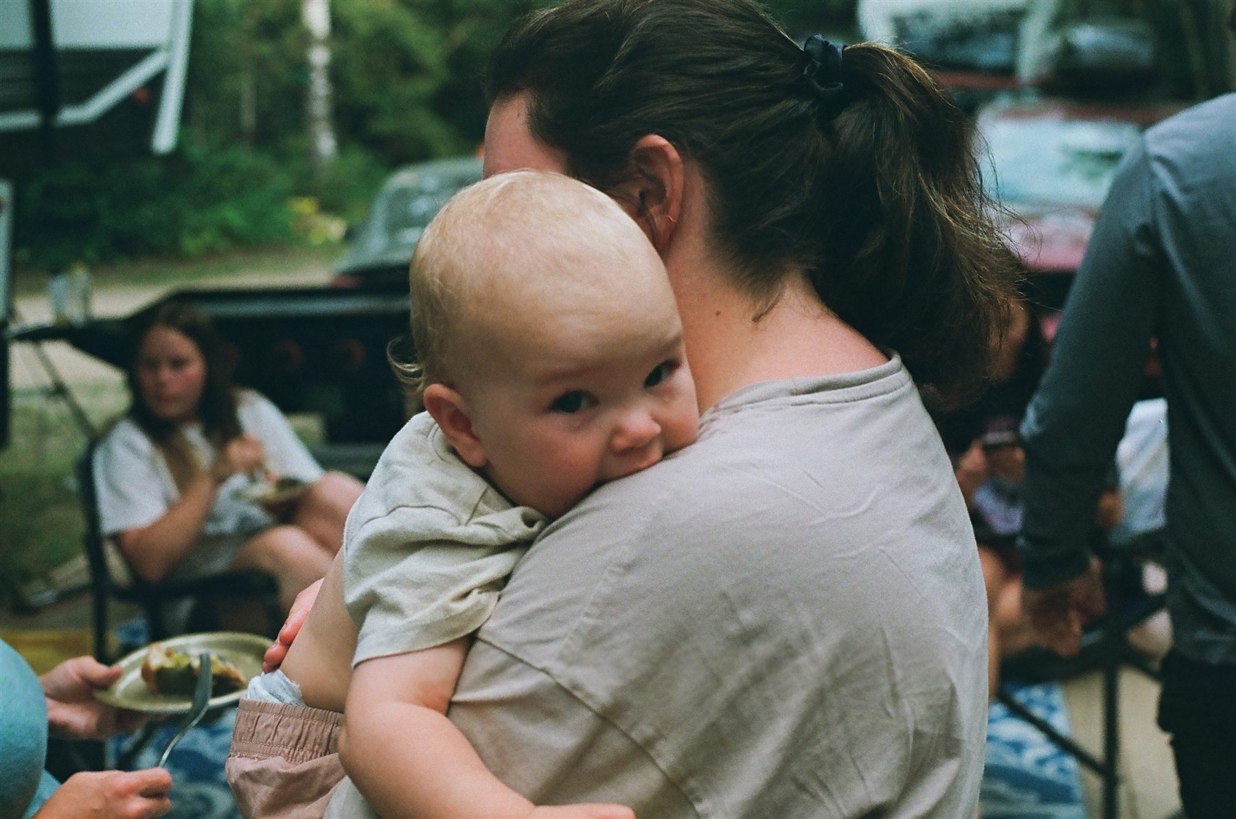 A woman holding a baby at a gathering