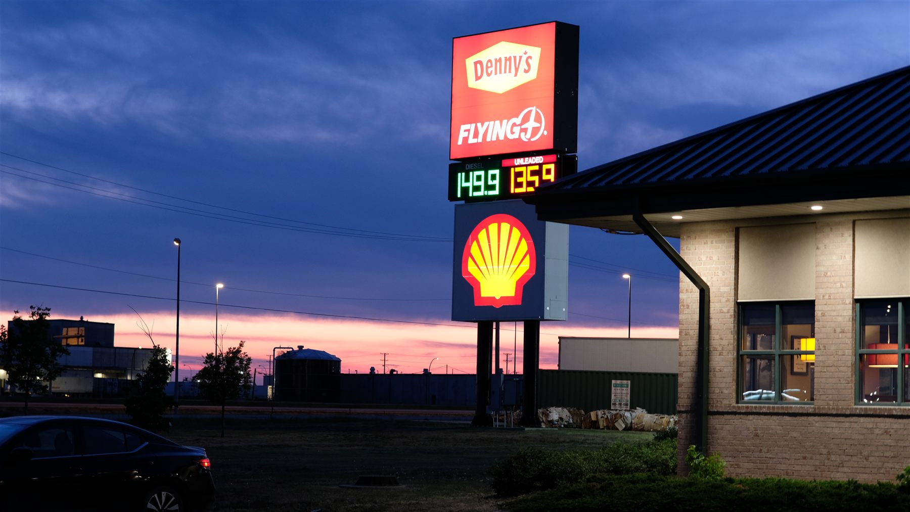A Denny's and Shell sign at dusk