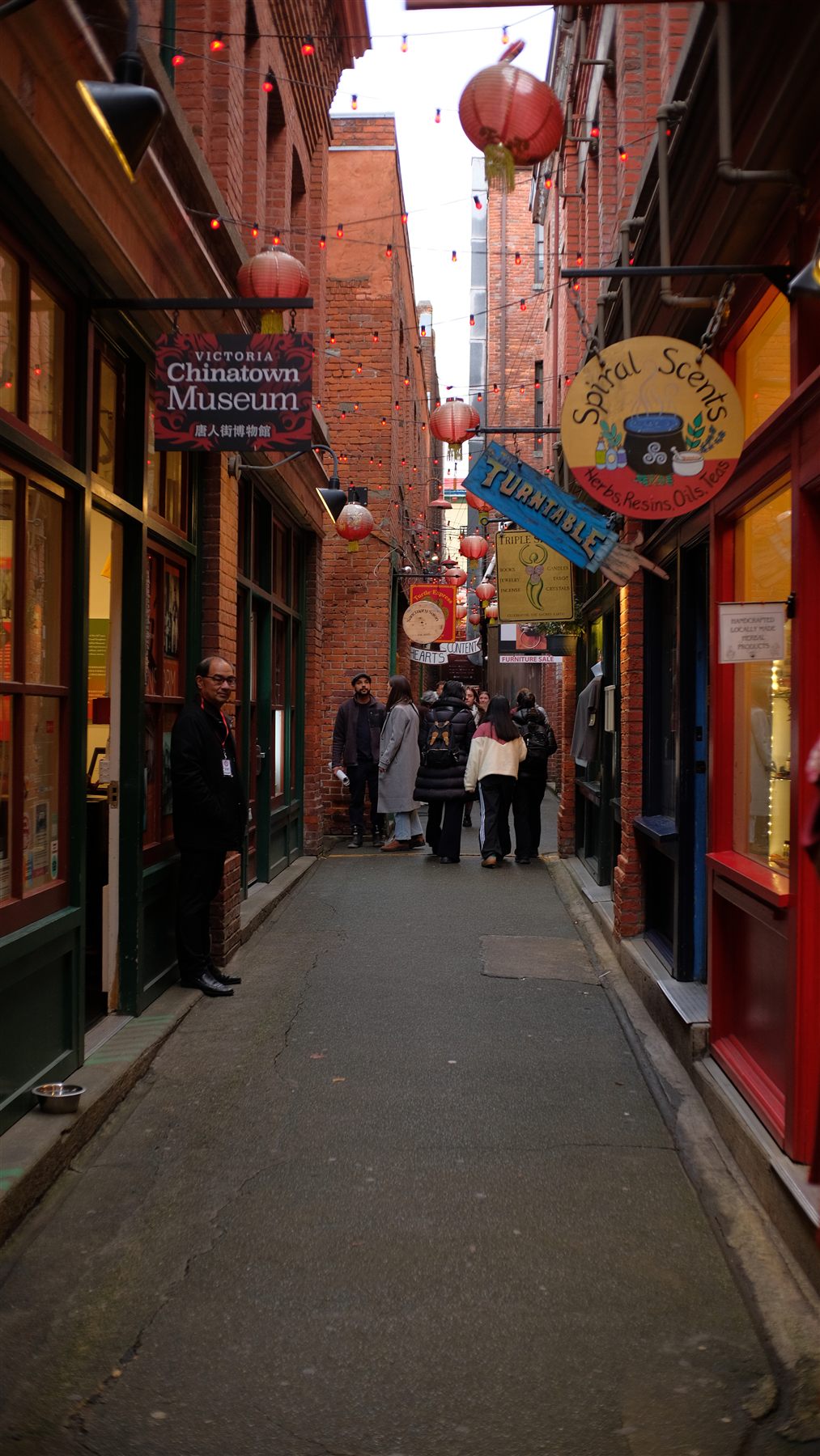 A narrow brick alley with shop signs