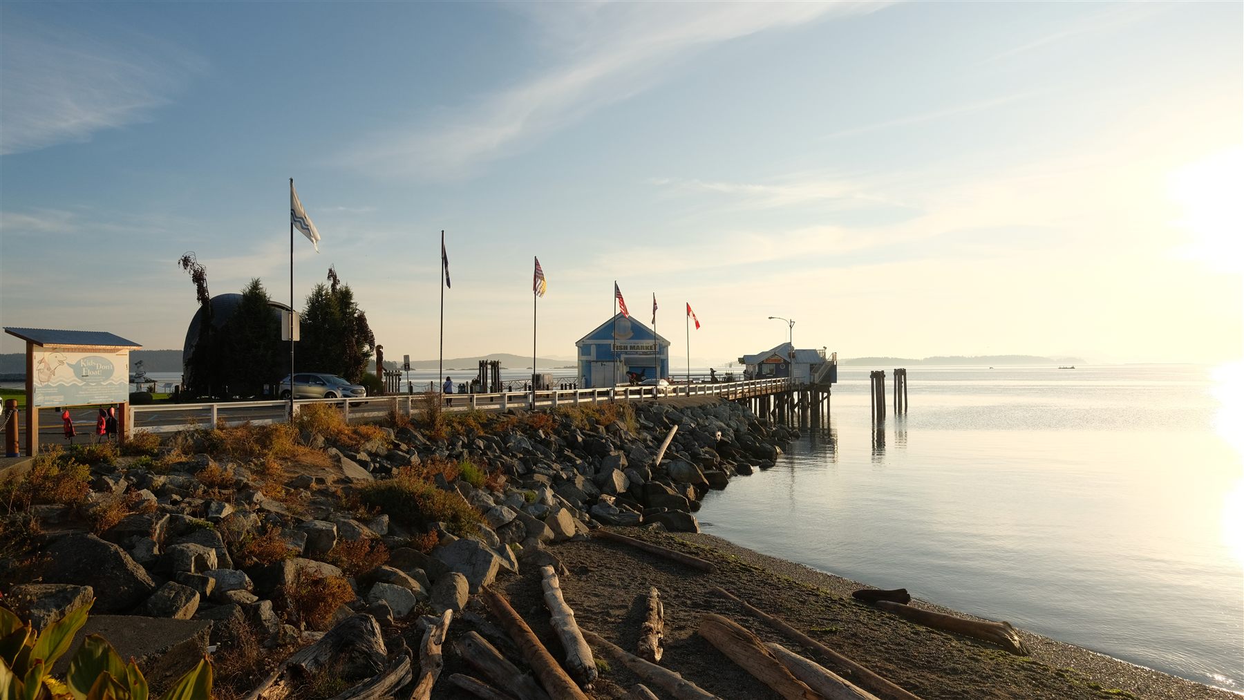 A pier with flags at sunset