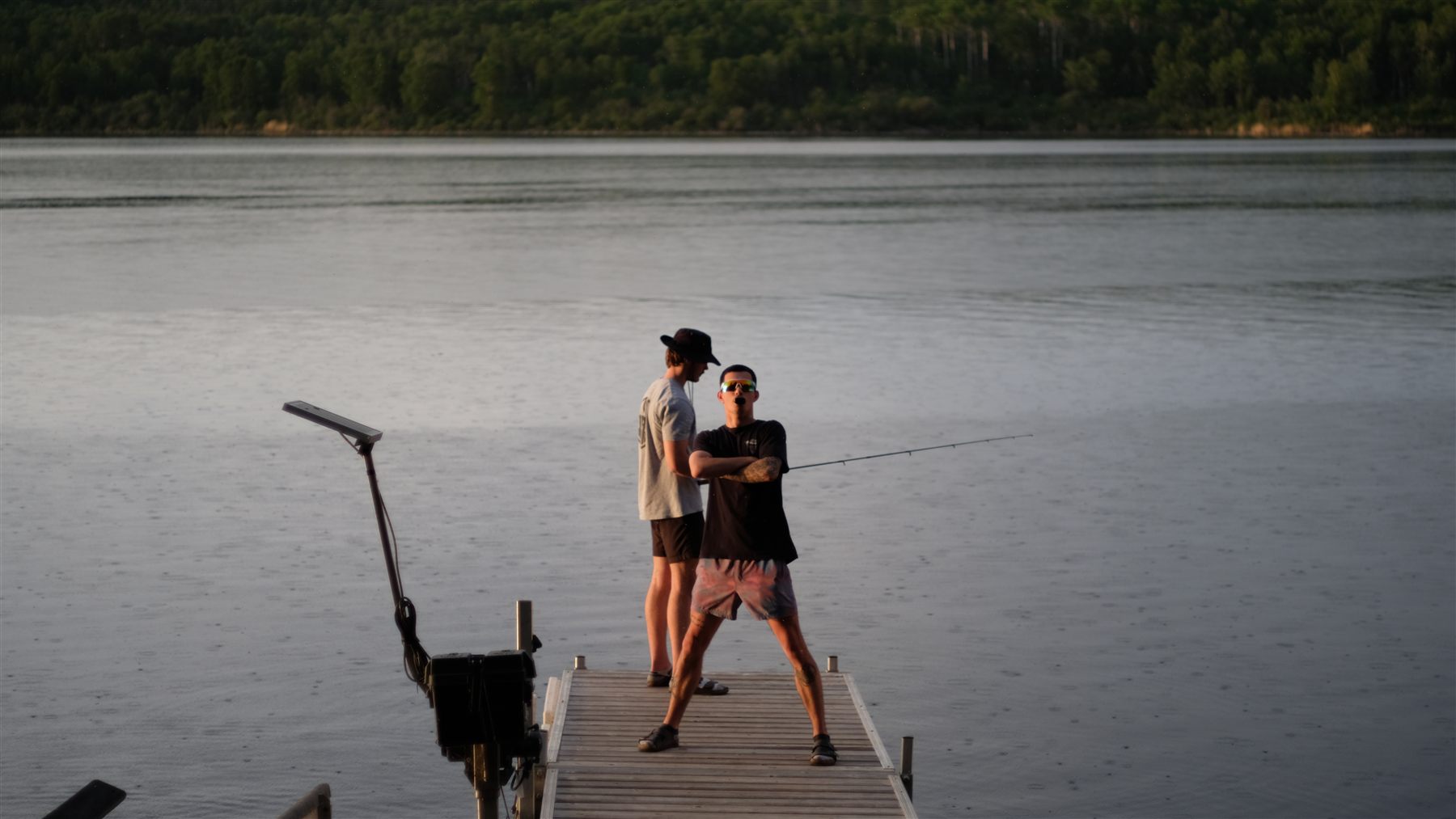 Two people on a dock with fishing rods