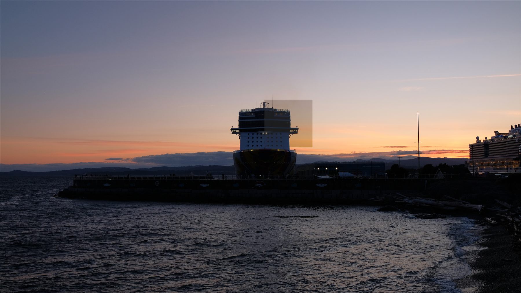 A lookout tower on the rocky shore at sunset